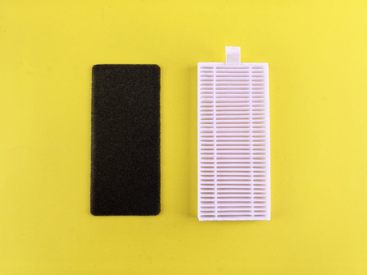 Black carbon pre-filter and white HEPA filter side by side showing air purifier filter components
