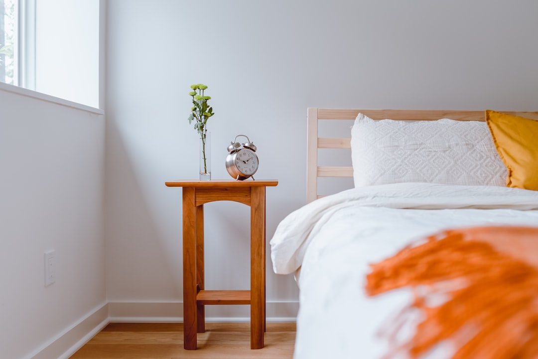 a neatly organized bedroom nightstand with minimal items, warm morning light, NYC apartment