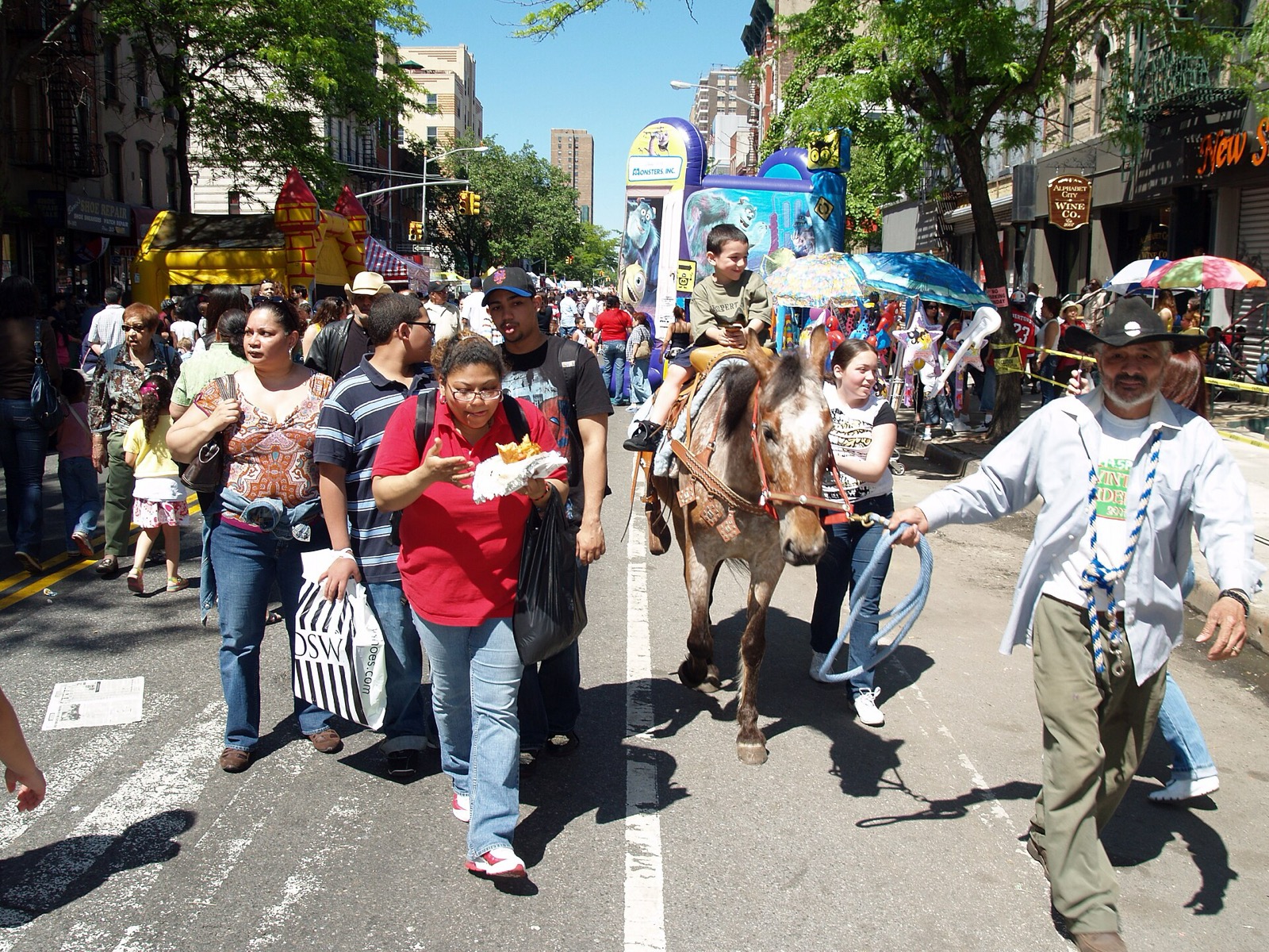 Loisaida Avenue C street festival in Alphabet City with residents celebrating Puerto Rican and Latino culture, live music, and food vendors along the neighborhood cultural spine