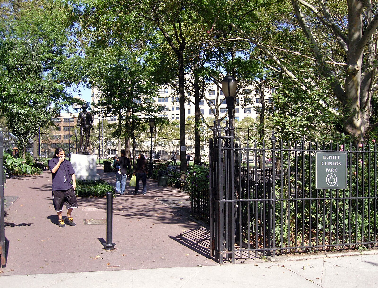 Brownstones and brick townhouses on a residential cross street in Clinton, Manhattan, between Ninth and Tenth Avenues, showing the surviving 19th-century domestic architecture that defines the quieter side of this neighborhood