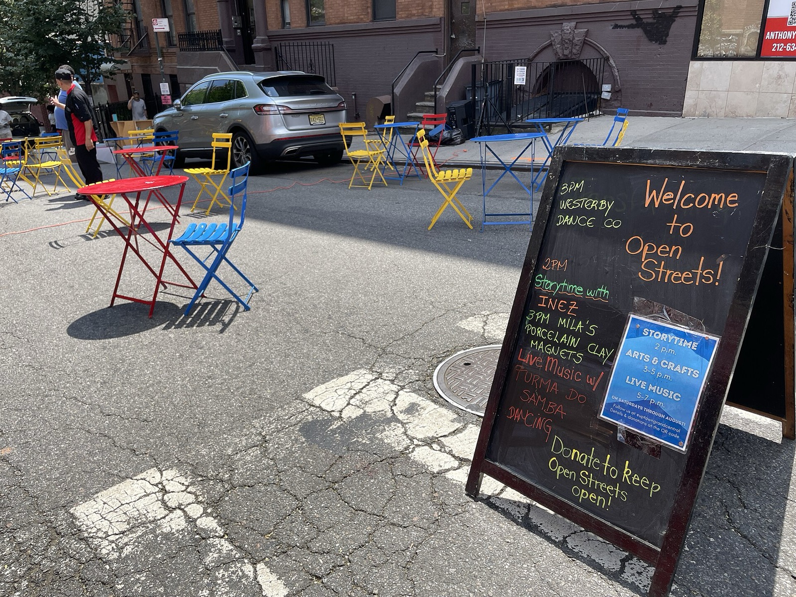 Lexington Avenue at 100th Street during an Open Streets event in East Harlem, with the neighborhood's mix of pre-war tenements and newer development visible along the avenue