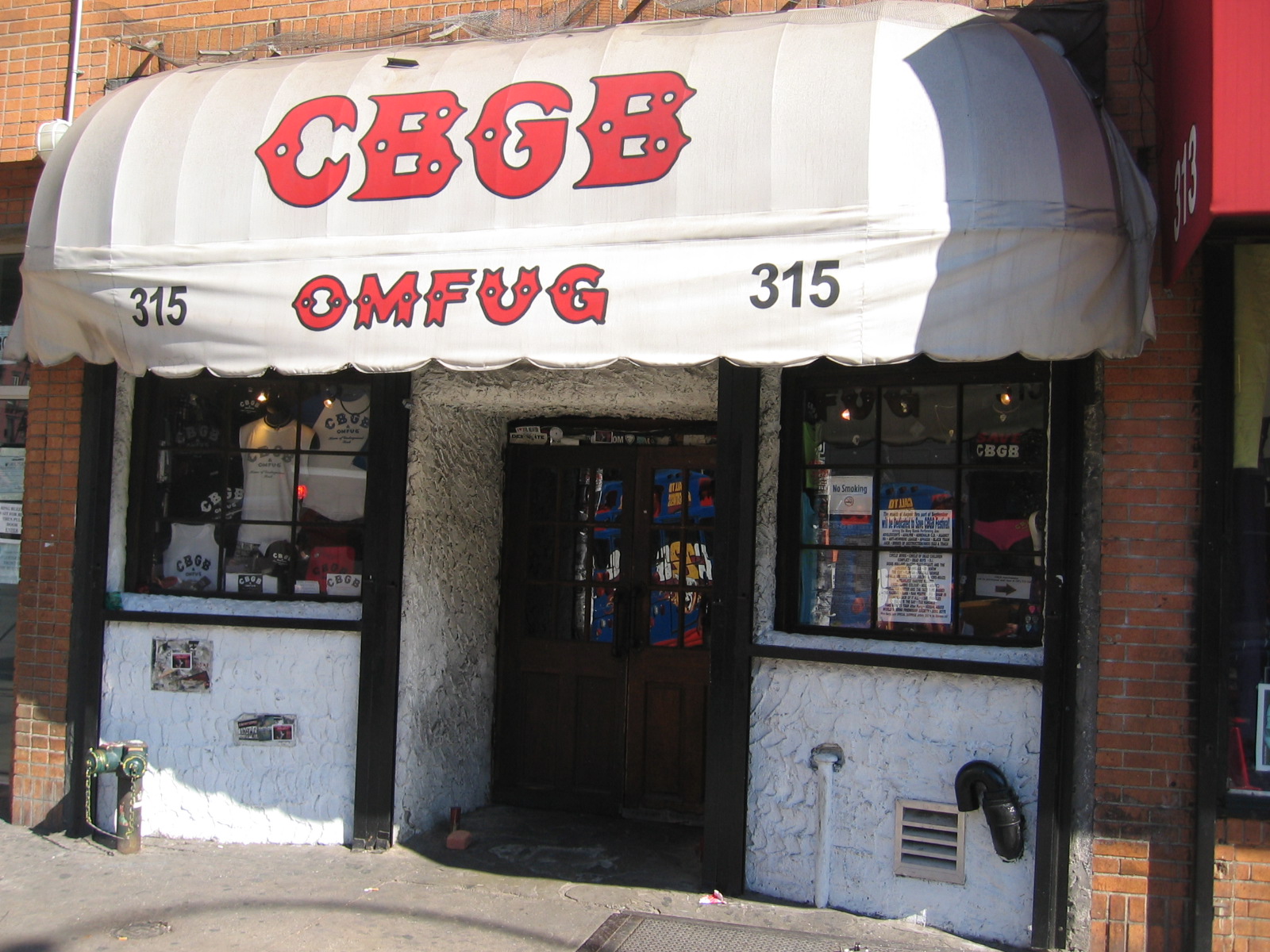 The facade of CBGB at 315 Bowery, the legendary punk rock venue that launched the Ramones, Blondie, and Talking Heads, covered in its signature stickers and graffiti before the club closed in 2006