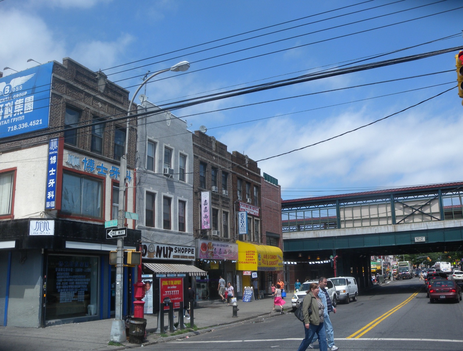 Storefronts including a dental office bakery and psychic reading shop line Avenue U in Homecrest Brooklyn beneath the elevated subway tracks