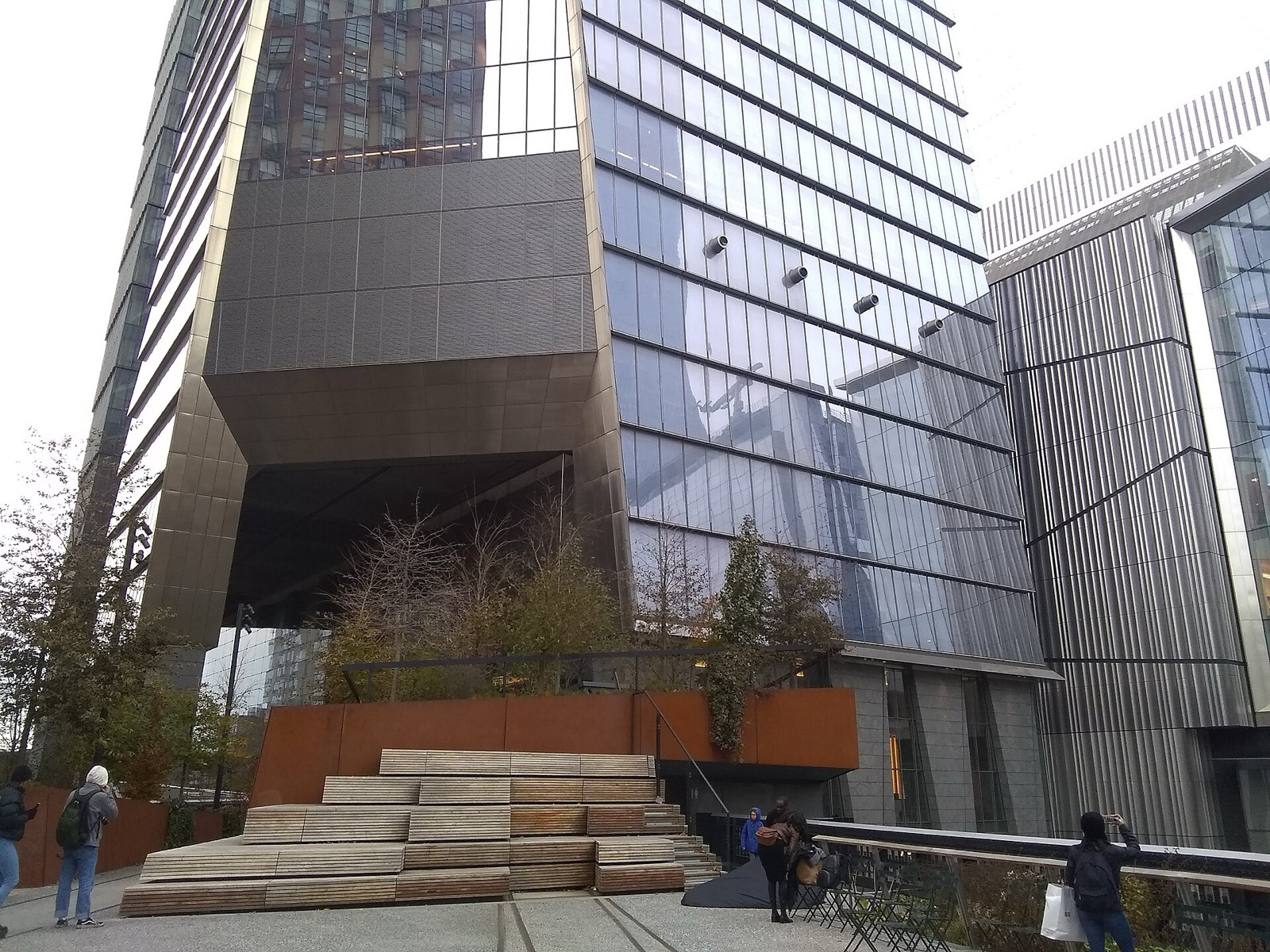 The High Line elevated park near Hudson Yards, looking south through the walkway surrounded by plantings with the towers and buildings of Chelsea visible