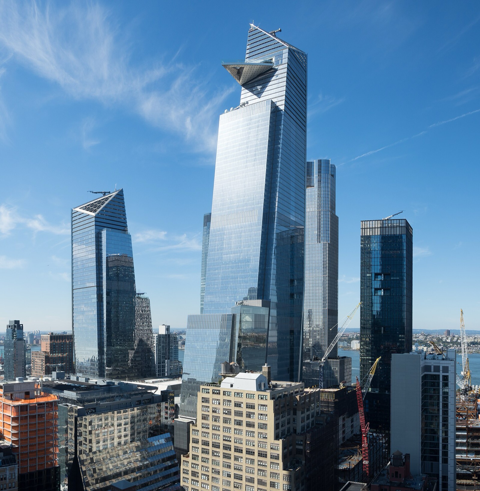 The Hudson Yards development viewed from Hudson Commons, showing the cluster of glass towers rising above the surrounding West Side neighborhood