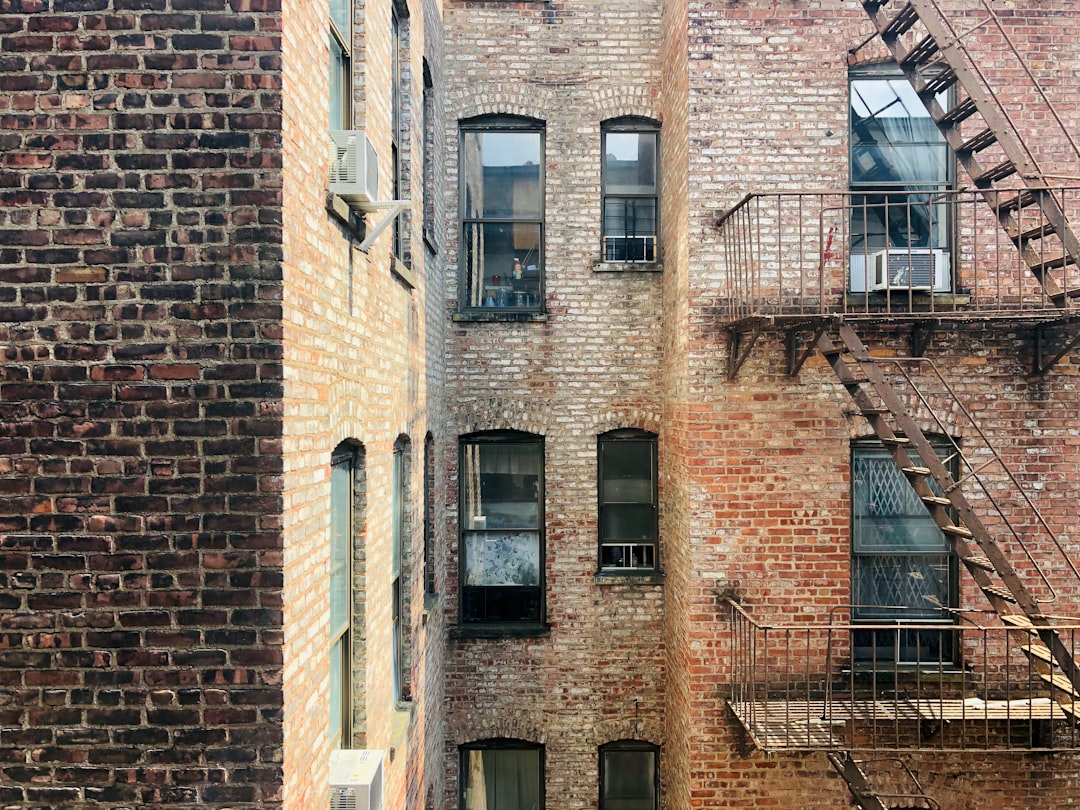 Residential brick street in Brooklyn showing a tall apartment building and the street-level character of a working-class southern Brooklyn block