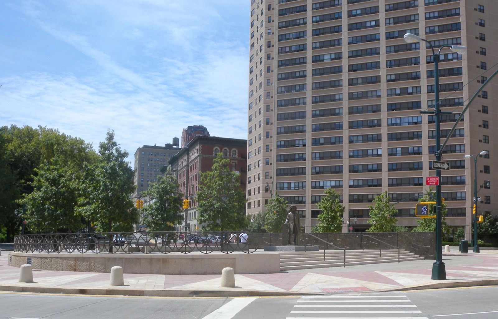 Frederick Douglass Circle at Central Park West and West 110th Street on a sunny midday, marking the northern boundary of Manhattan Valley