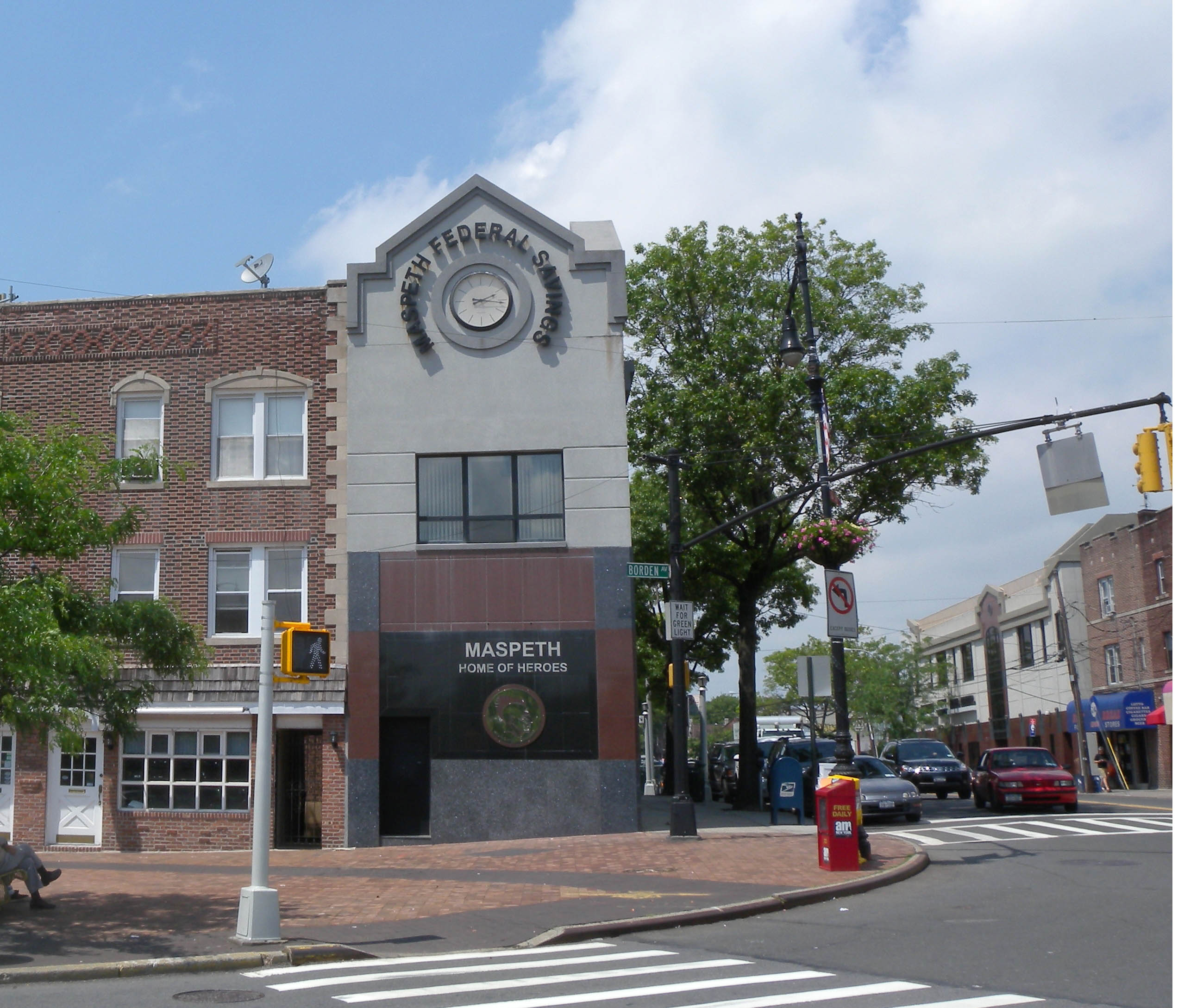 Grand Avenue commercial strip in Maspeth showing the two and three story prewar brick buildings with retail below and apartments above that line the neighborhood's main business corridor