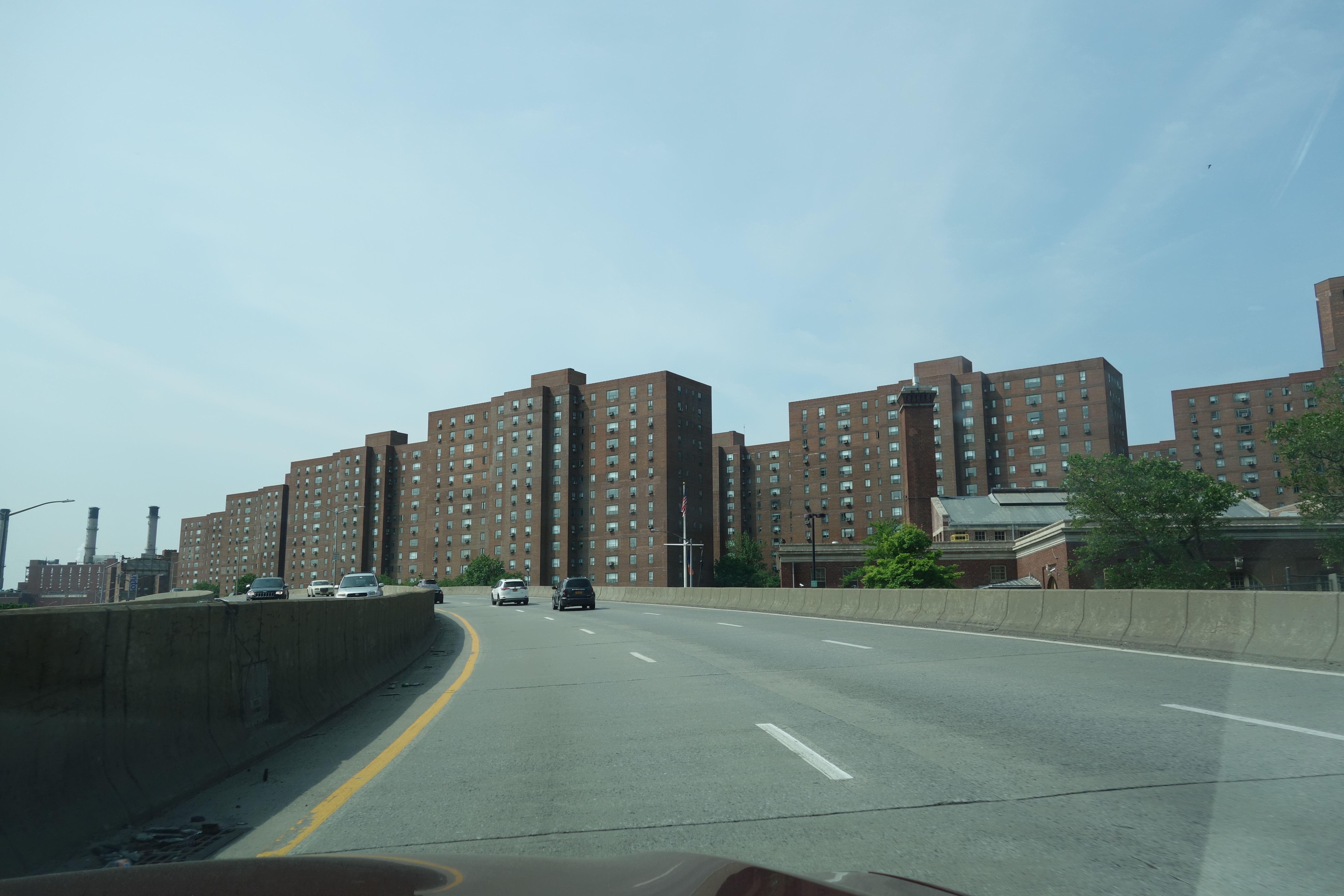 The East River Greenway running along the FDR Drive at the eastern edge of Peter Cooper Village, with the waterfront path, mature trees, and the East River visible