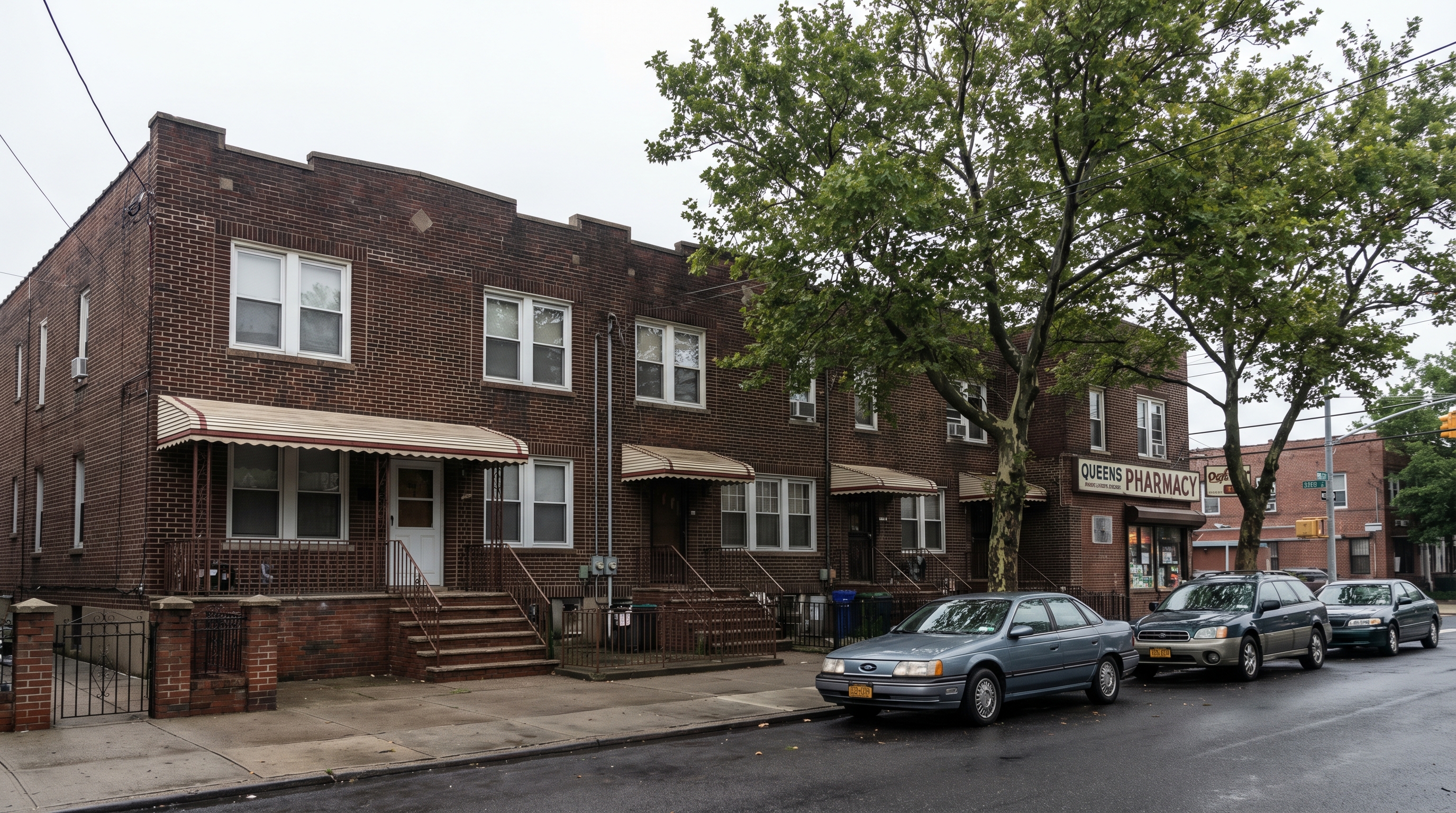 A block of attached two-story brick row houses in South Ozone Park Queens with awnings, corner pharmacy, and mature street tree