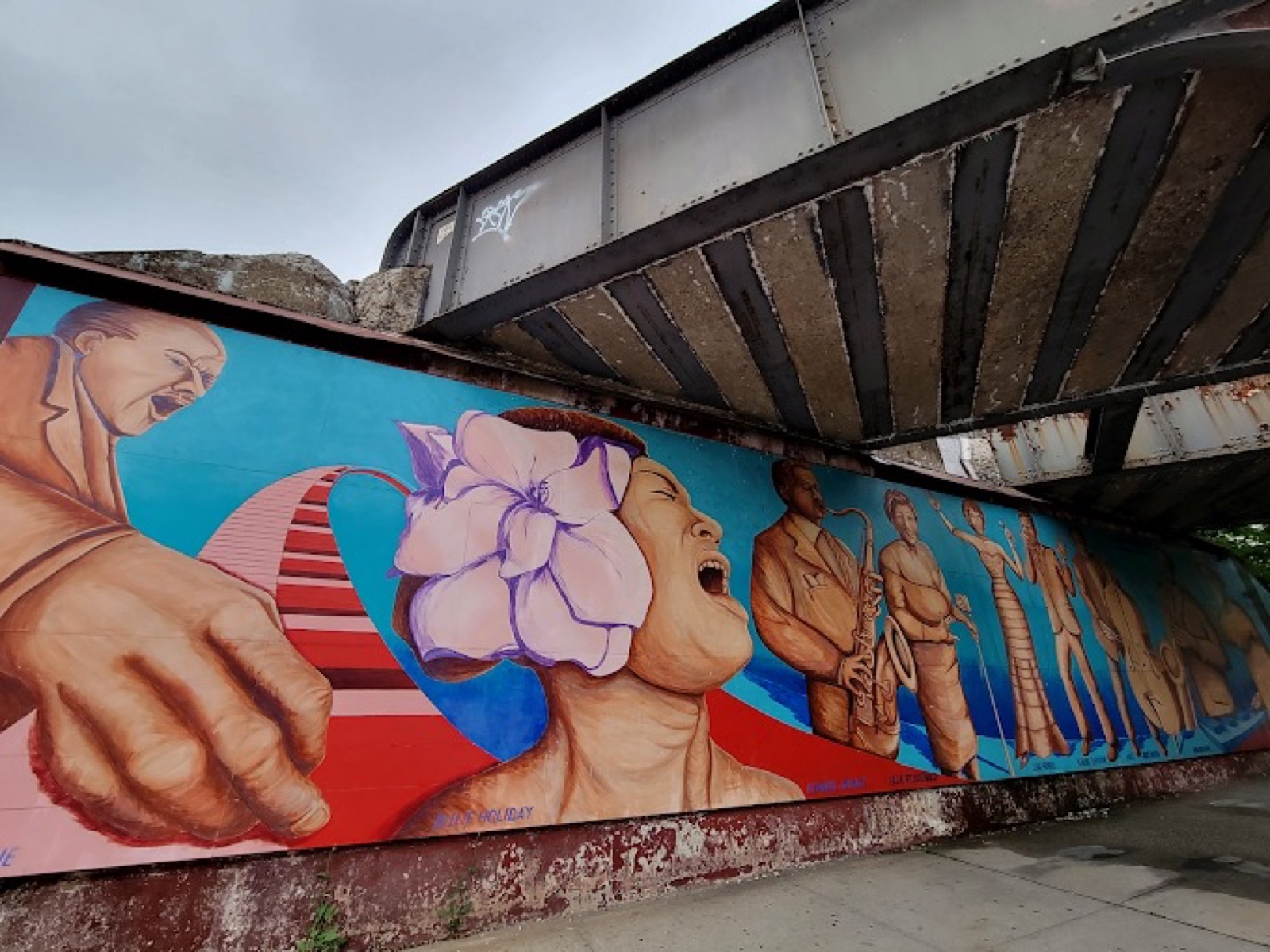 The Billie Holiday panel of the St. Albans Greatest mural, depicting Holiday singing with her signature flower, alongside saxophonists and other musicians who called this neighborhood home