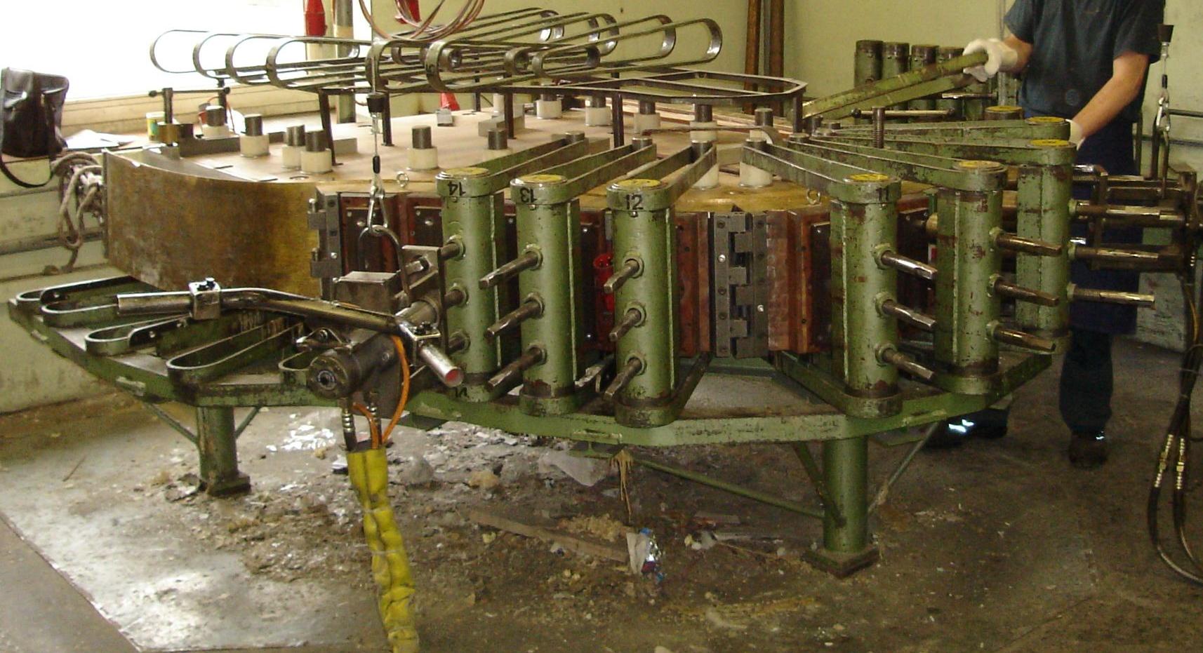 Workers bending the curved outer rim of a Steinway concert grand piano by hand at the Steinway & Sons Queens factory