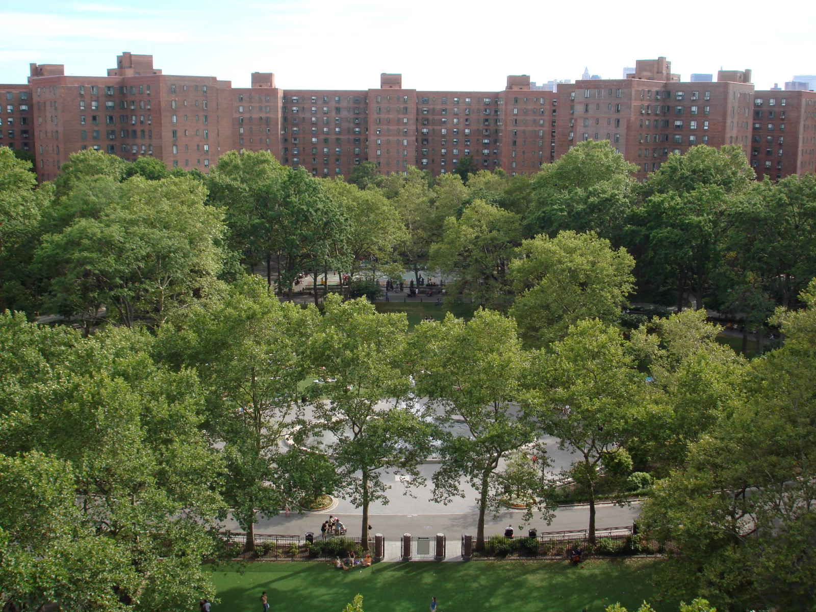 The Oval green at the center of Stuyvesant Town with mature trees, benches, and pedestrian pathways connecting the 35 residential towers