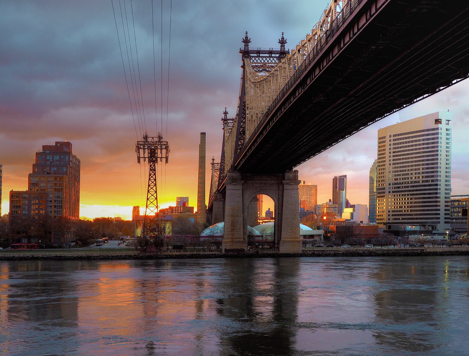 The Queensboro Bridge and Roosevelt Island at dawn seen from the East River, the iconic view visible from Sutton Place residences every morning