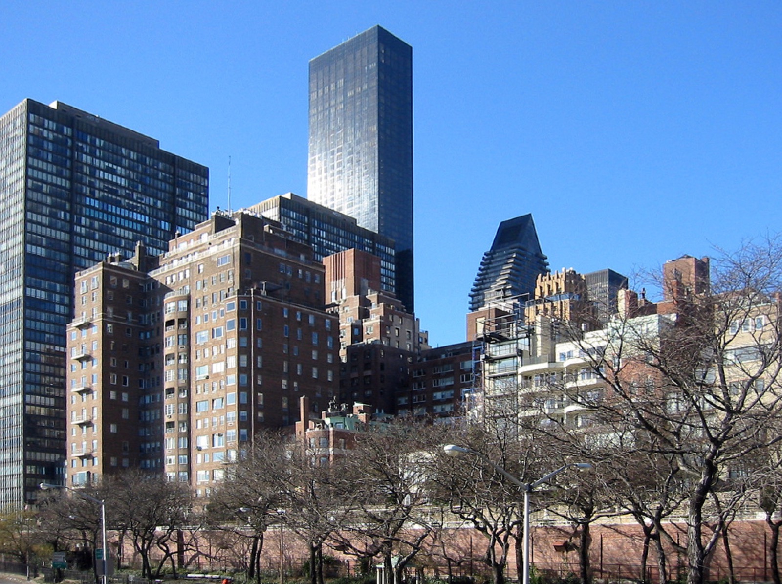 Sutton Place Manhattan street view looking east toward the East River, showing the quiet tree-lined residential character of the neighborhood
