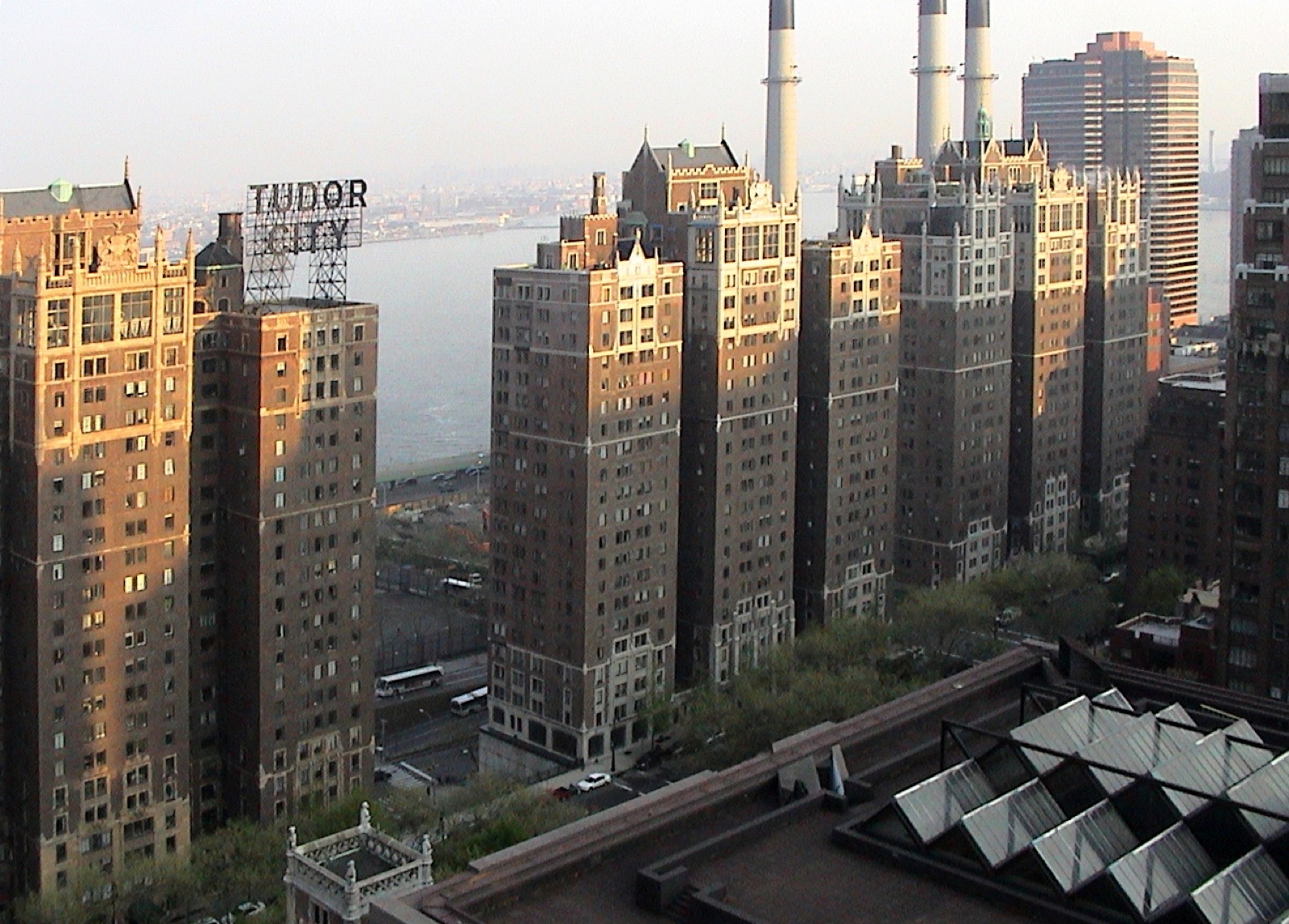 Tudor City complex and the East River as seen from a distance, showing the Gothic Revival towers rising above the Midtown East skyline with the river behind