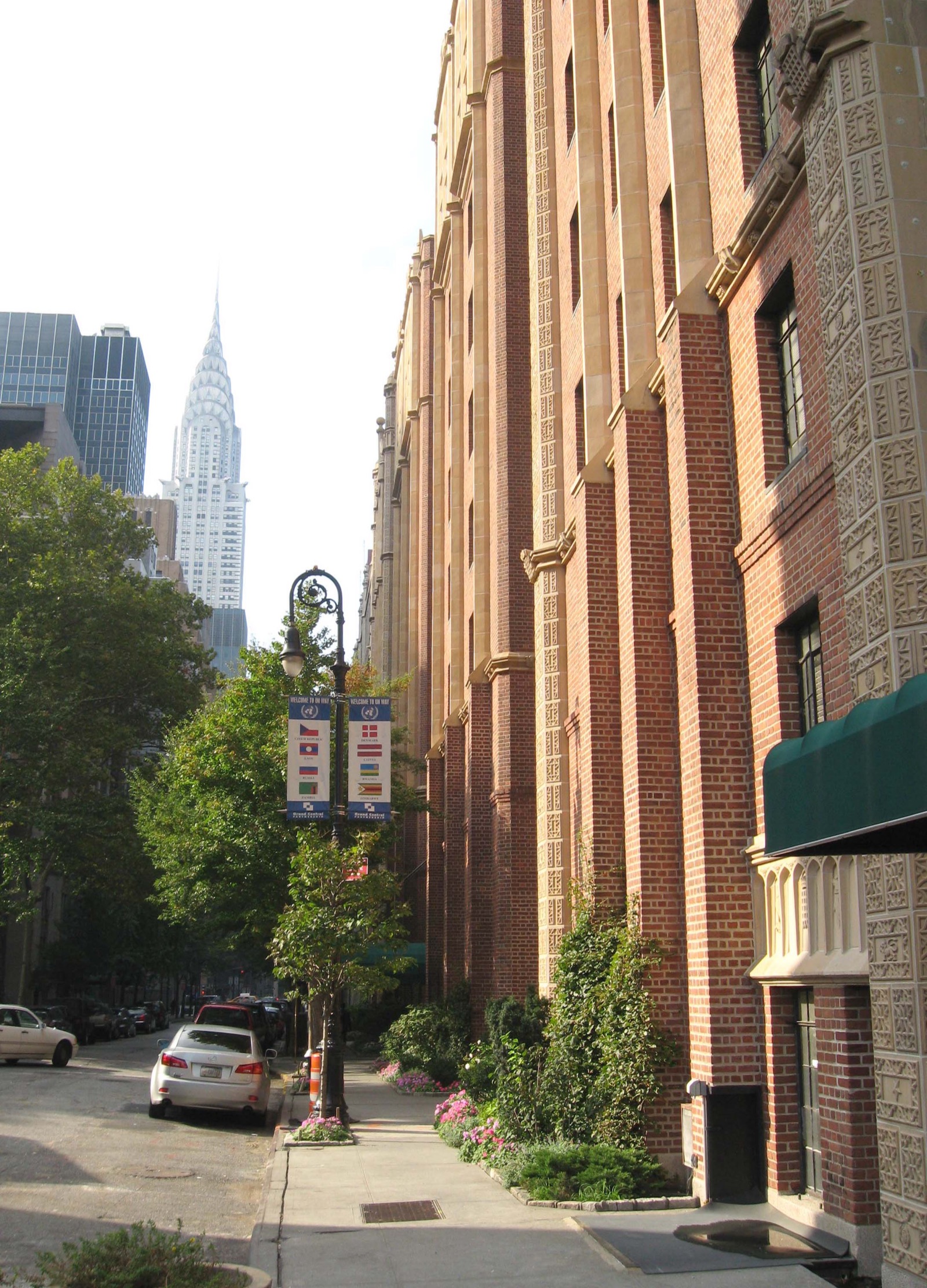 The Tudor Gothic facades along 43rd Street in Tudor City, showing the ornate red brick towers with pointed arches and decorative stonework that define the complex