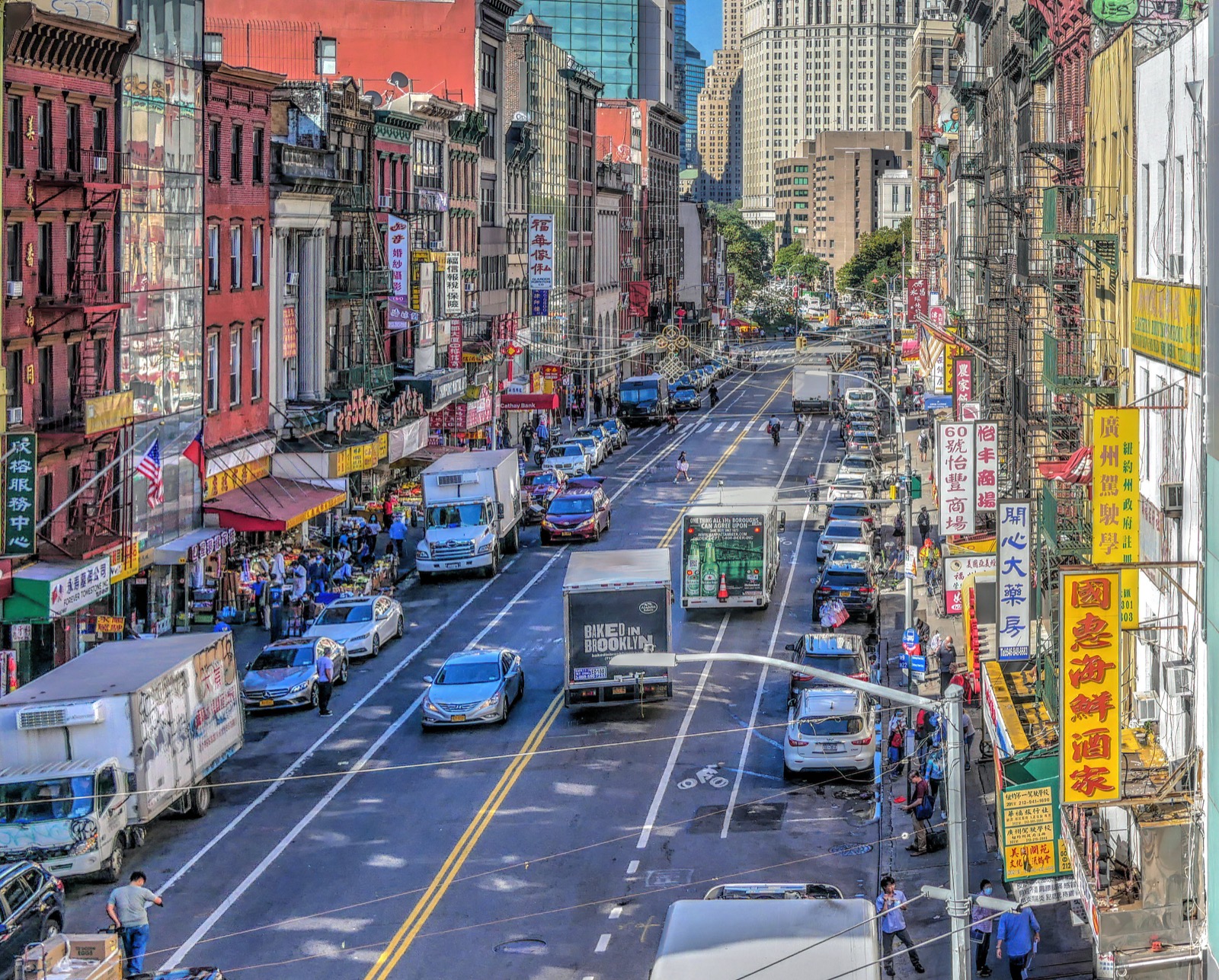Looking toward East Broadway and the Lower East Side from the Manhattan Bridge walkway, showing the dense streetscape of Two Bridges and Little Fuzhou below