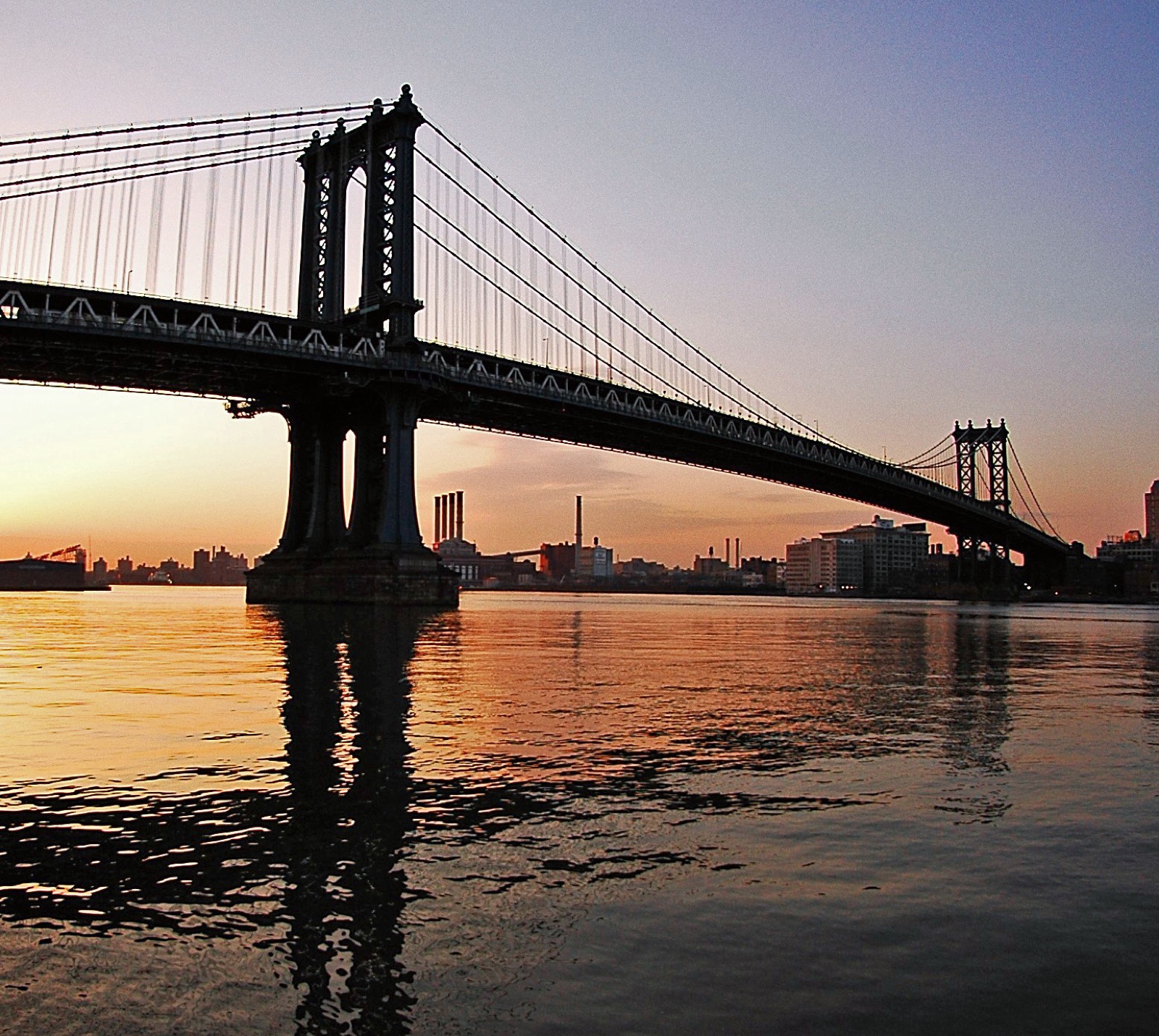 The Manhattan Bridge completed in 1909, the eastern boundary of Two Bridges, carrying B and D subway trains whose sound is the constant ambient backdrop of the neighborhood