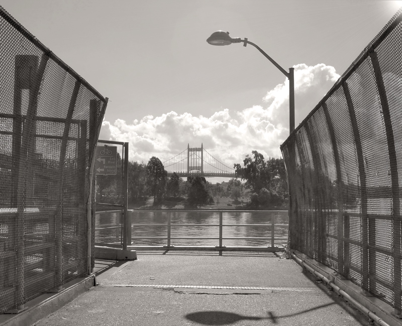 The 103rd Street Footbridge crossing toward Wards Island, the 12-foot-wide pedestrian and bicycle swing bridge that provides 24-hour access from Manhattan's East Harlem to the island