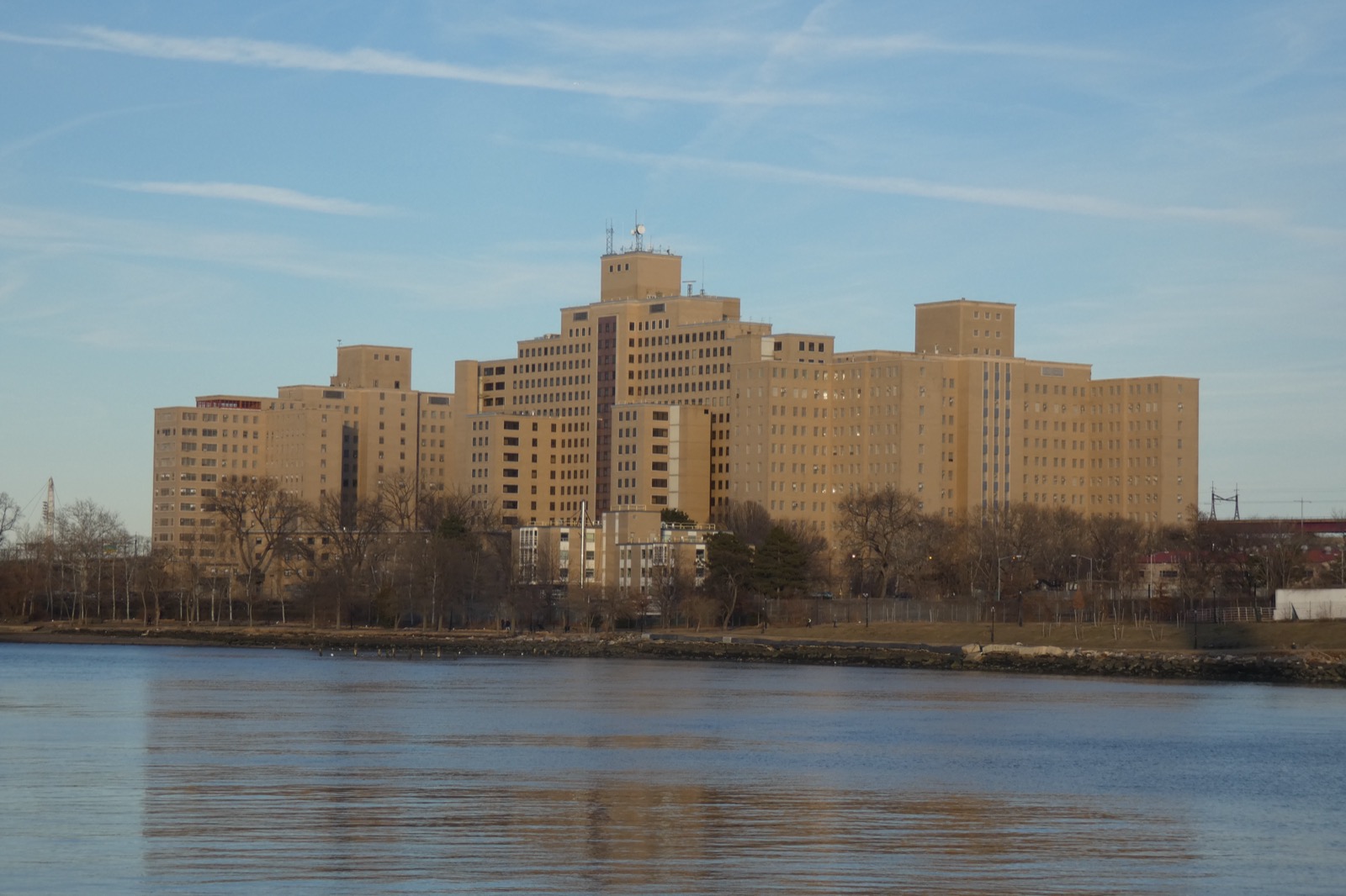 The Manhattan Psychiatric Center campus seen across the Harlem River, the surviving institutional buildings on the southern portion of Wards Island that once housed the world's largest mental institution