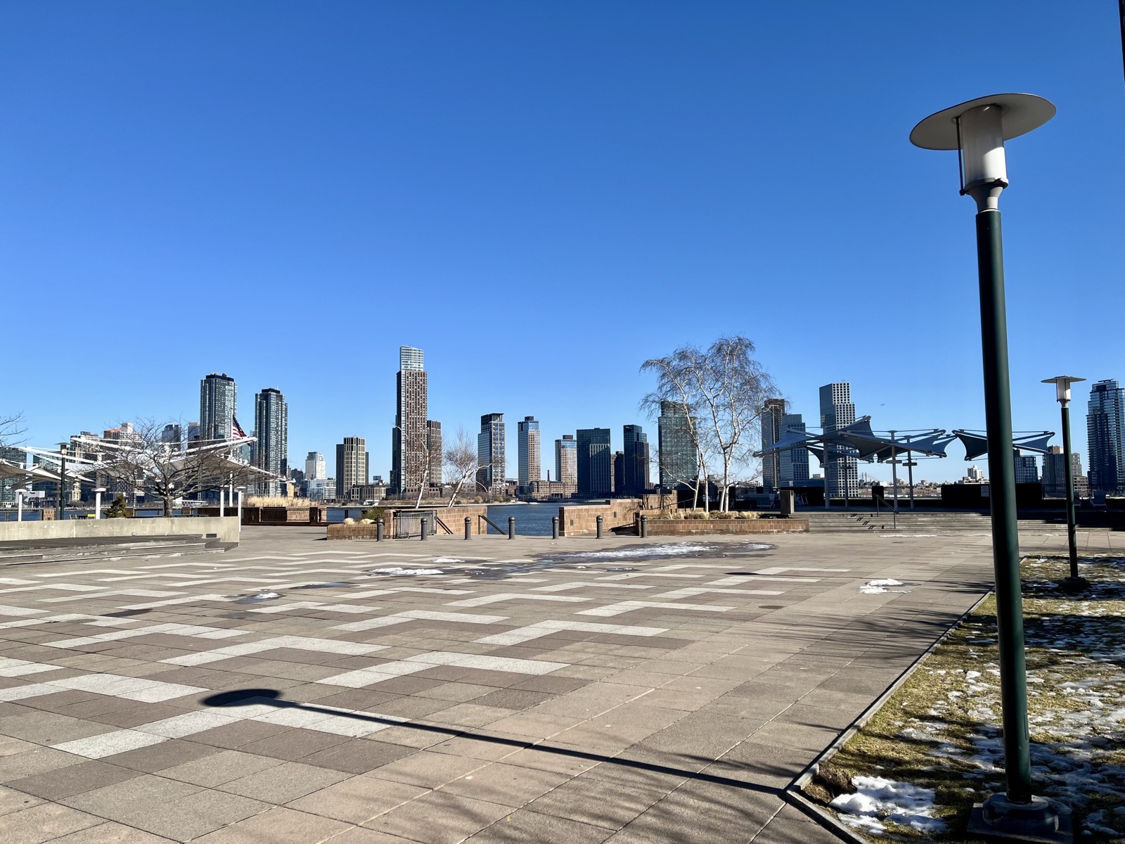 The elevated plaza deck at Waterside Plaza looking east between the residential towers, showing the car-free pedestrian environment and landscaping above the East River