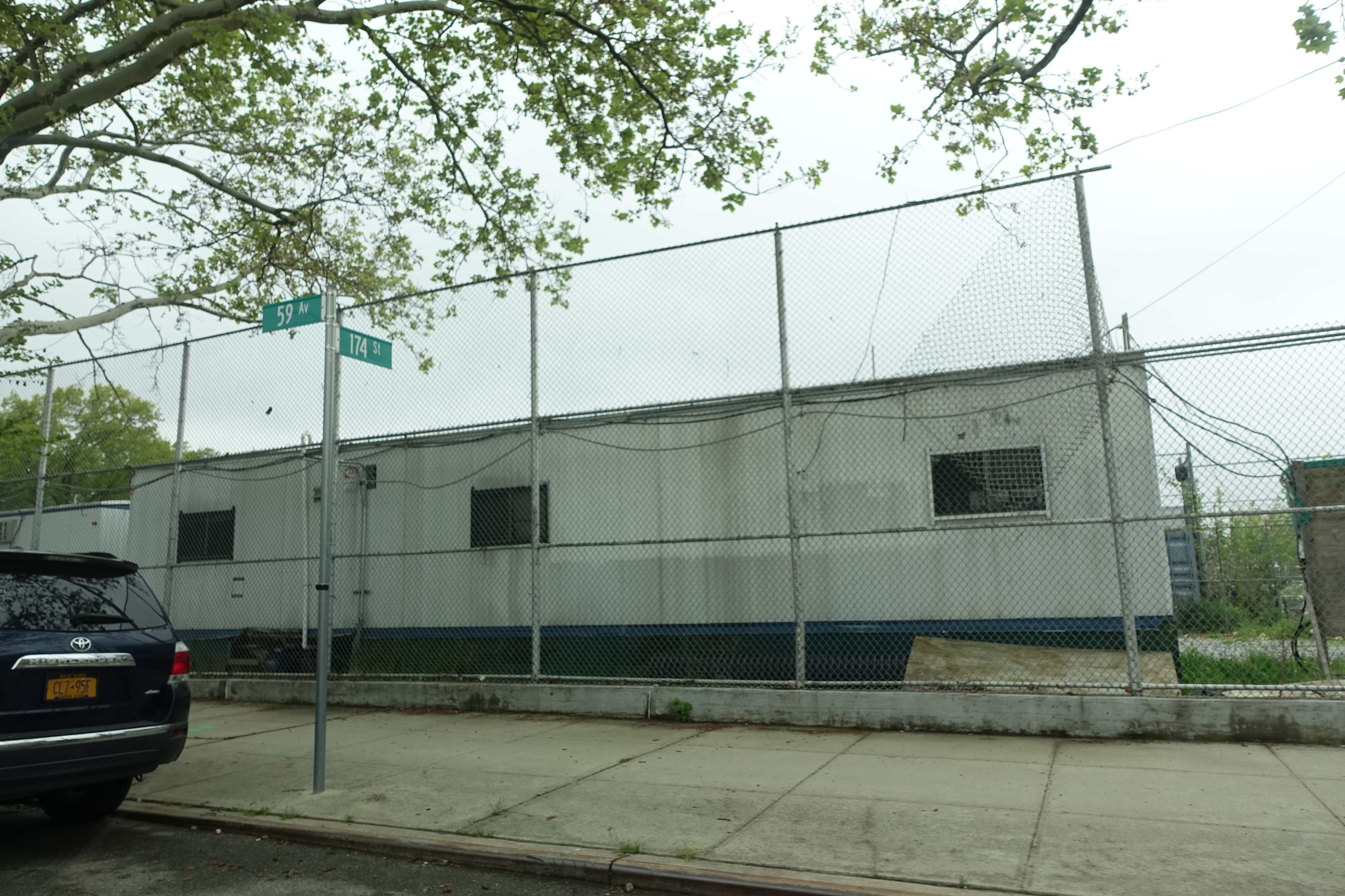 Francis Lewis High School exterior at 58-20 Utopia Parkway in Whitestone Queens, a large public high school building on a clear spring day showing the main entrance and grounds