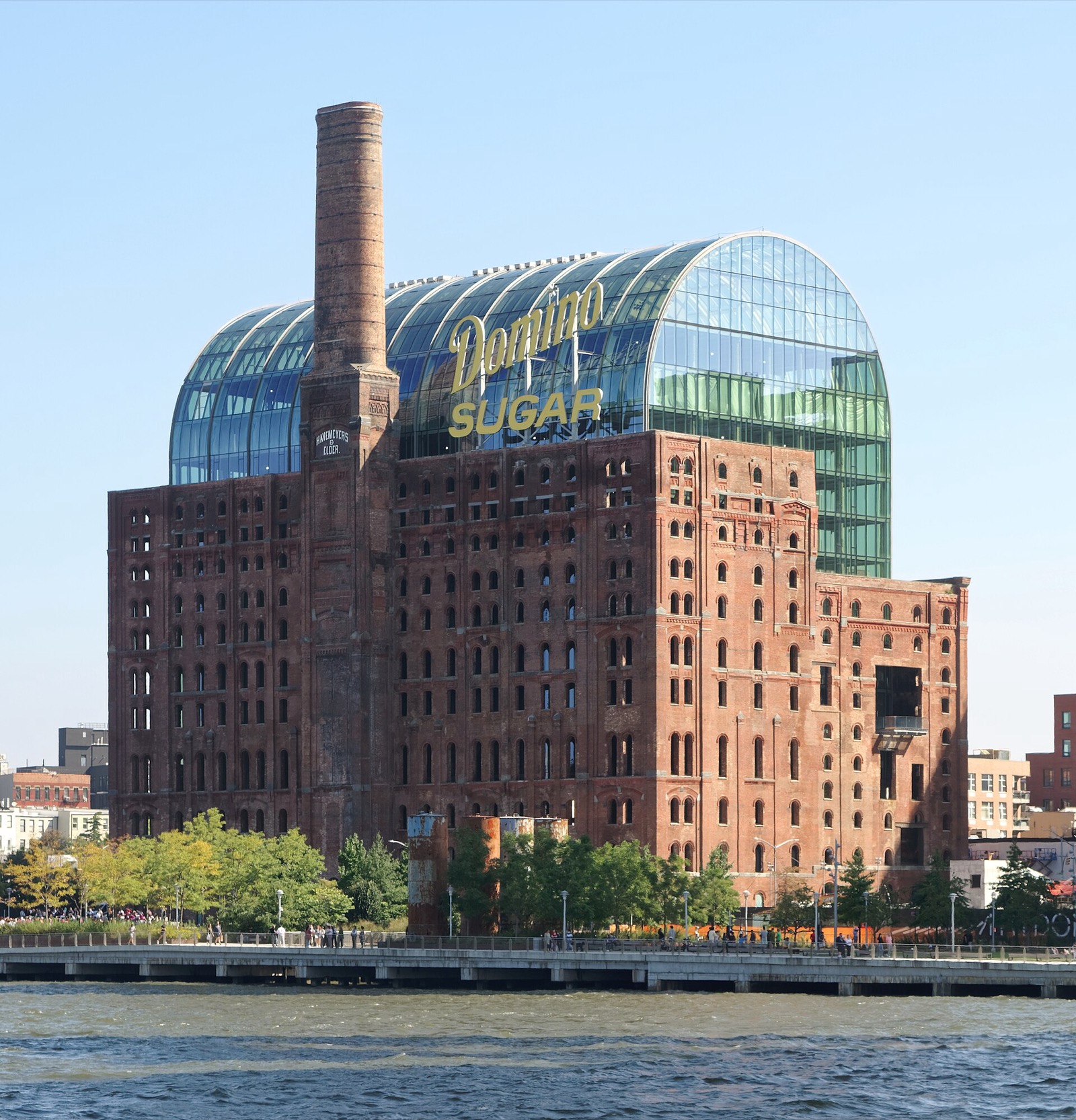 The Domino Sugar Refinery building in Williamsburg Brooklyn, its landmark red brick facade and industrial architecture preserved as a creative office complex along the East River waterfront