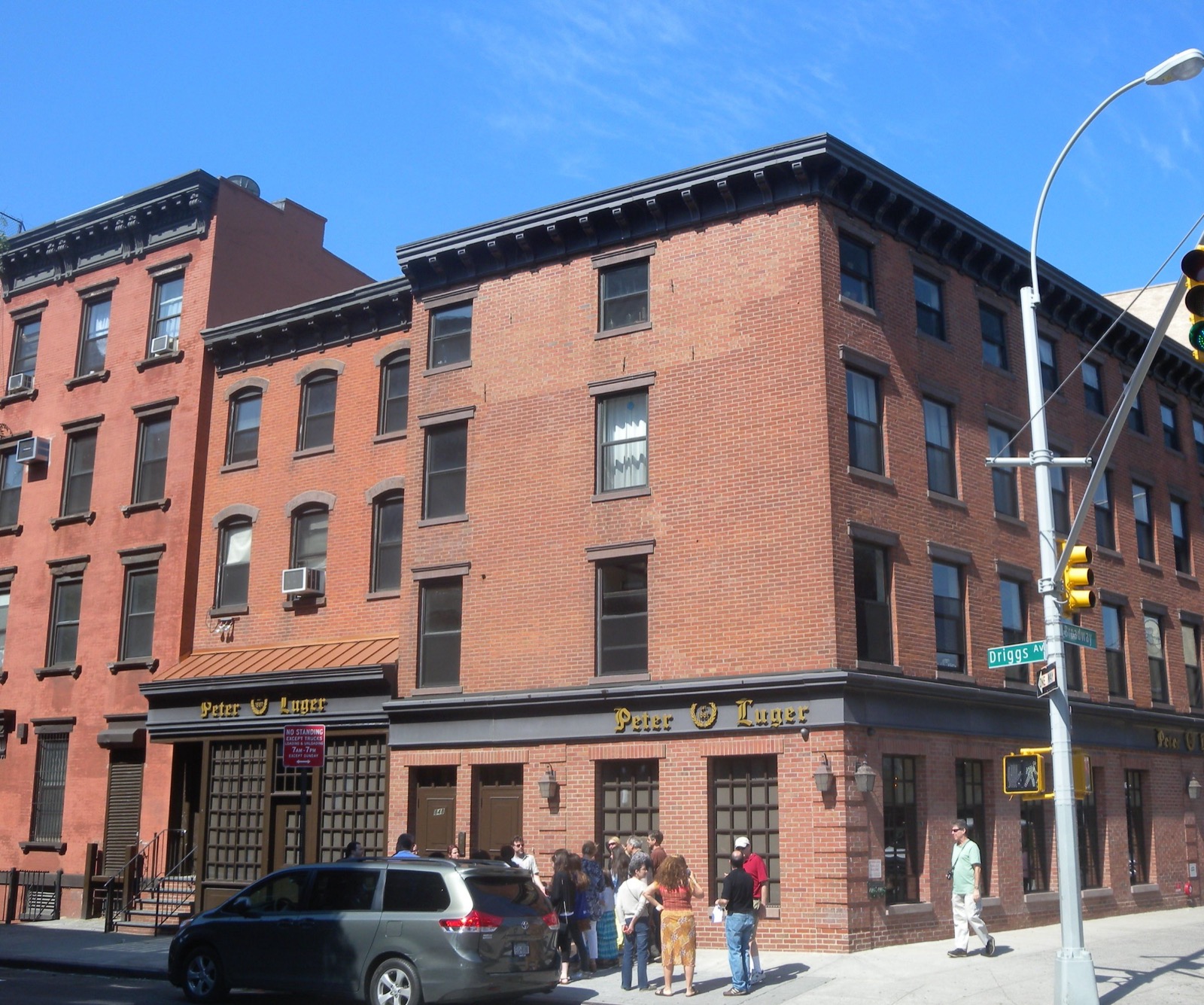 The redbrick exterior of Peter Luger Steak House on the corner of Broadway and Driggs Avenue in Williamsburg Brooklyn with its gold lettering sign above the entrance